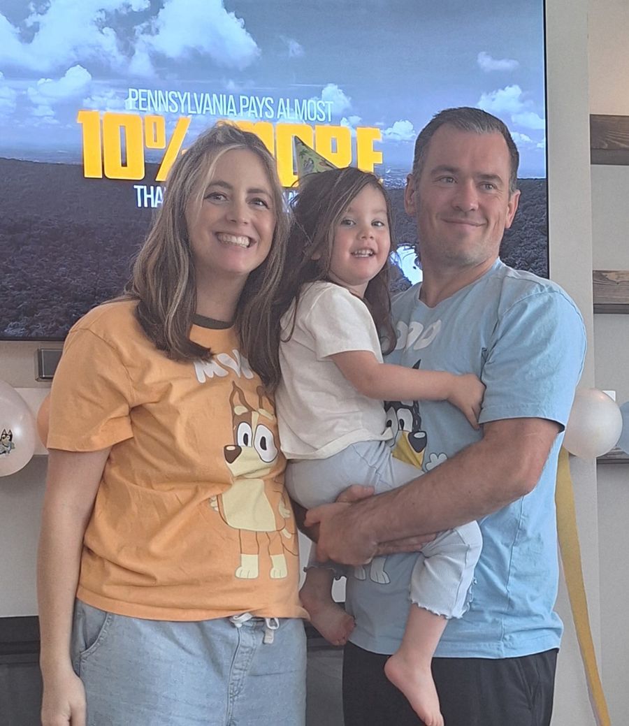 Mandy and Kyle in their Bluey shirts, holding Vera